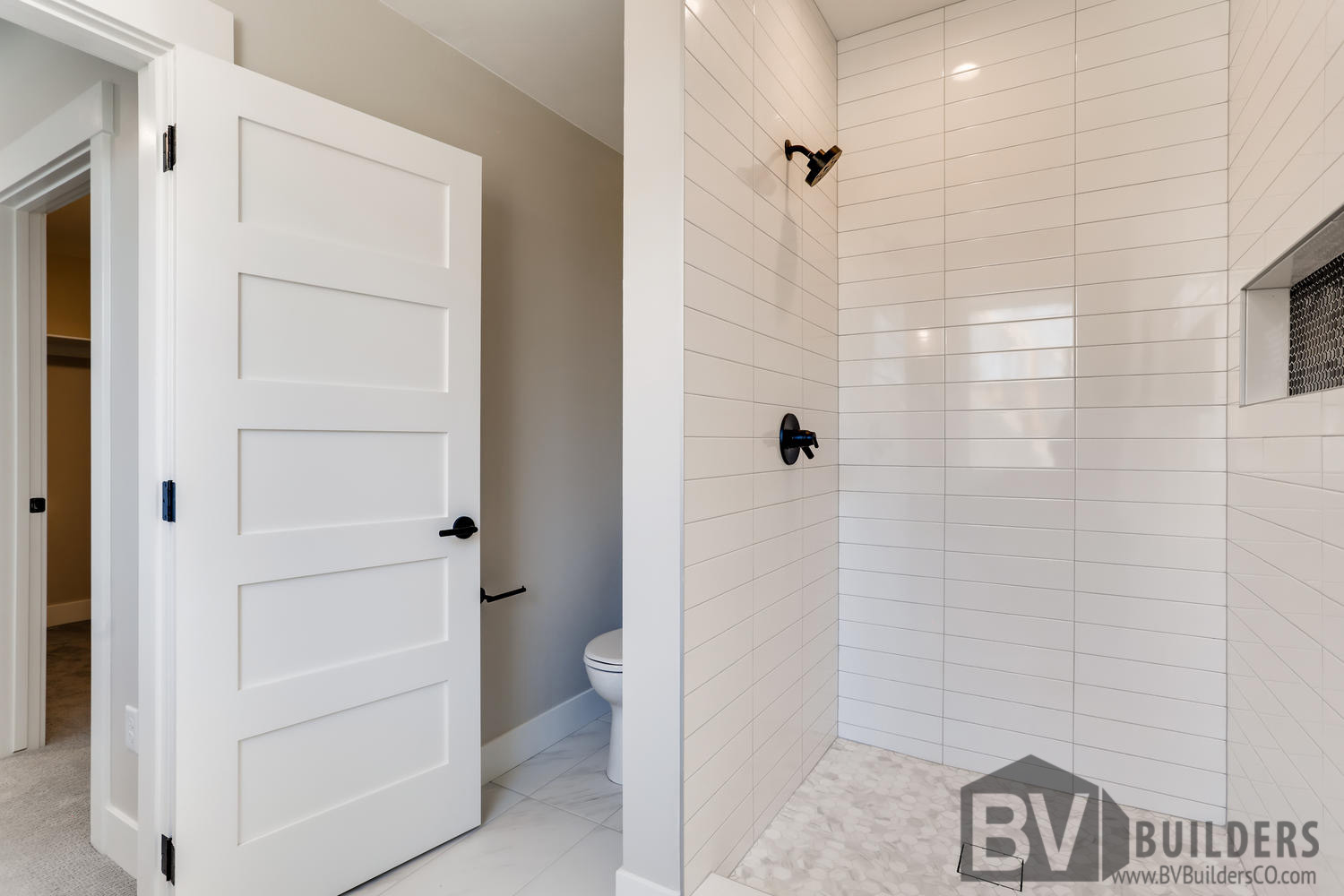 Shower with white subway tile straight set and black penny tile niche