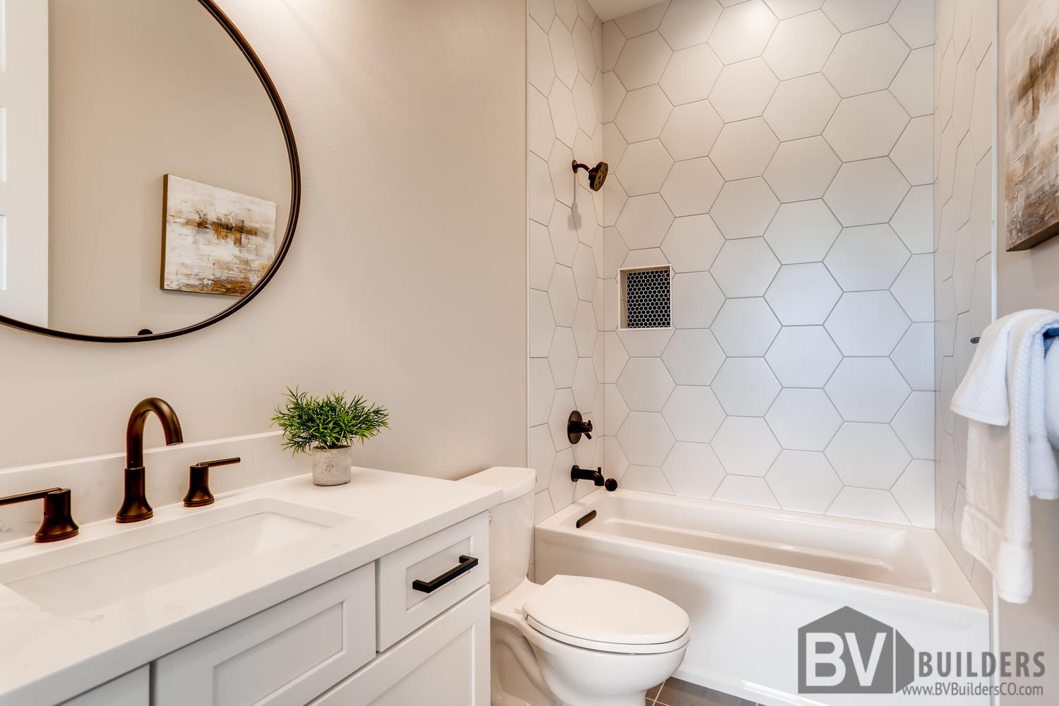 Full bathroom with marble hexagon tile and black penny tile niche