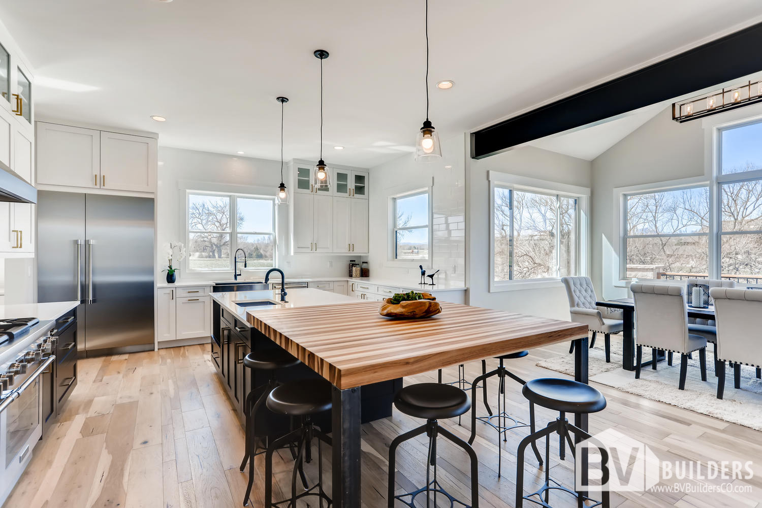 Modern farmhouse kitchen with exposed steel beams and butcher block bar