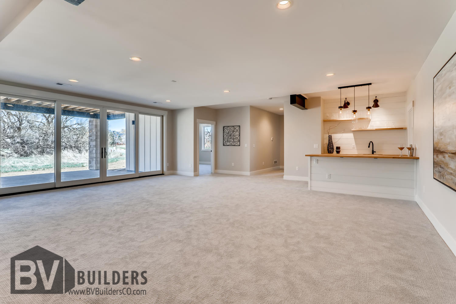 Walkout basement great room with shiplap wet bar