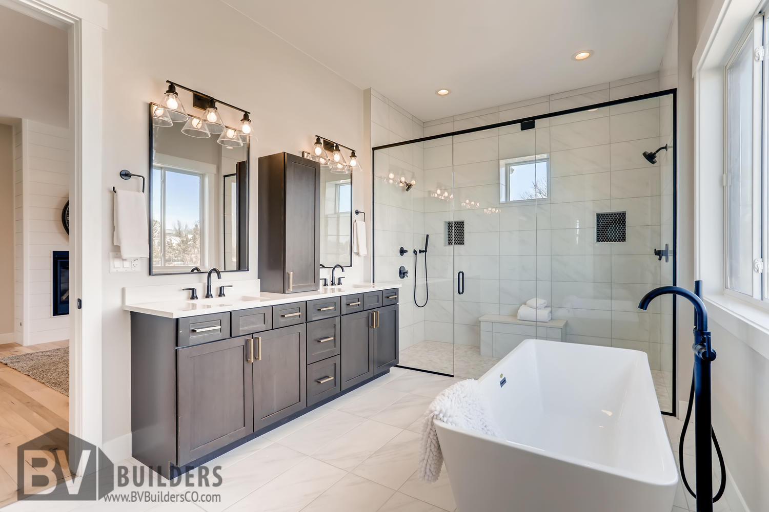 Modern farmhouse master bathroom with double vanity, soaker tub and glass shower door