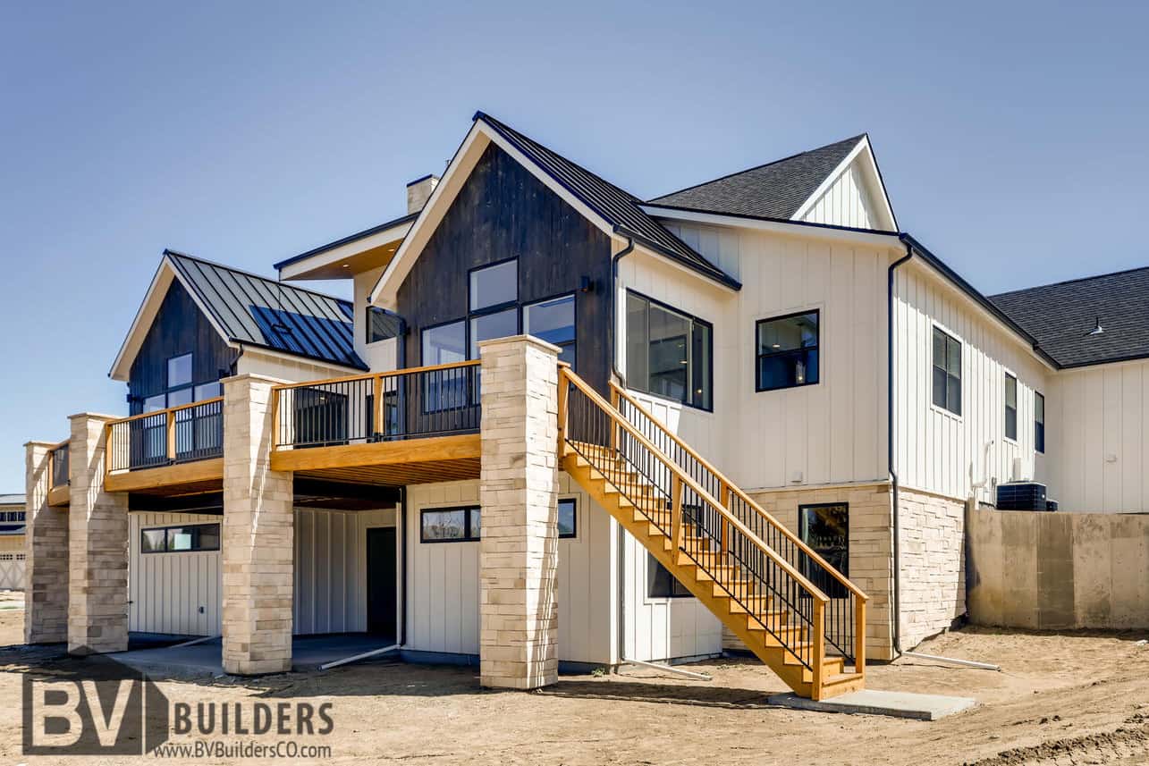 Modern farmhouse with a wood deck Thermory wood vertical siding and walkout basement