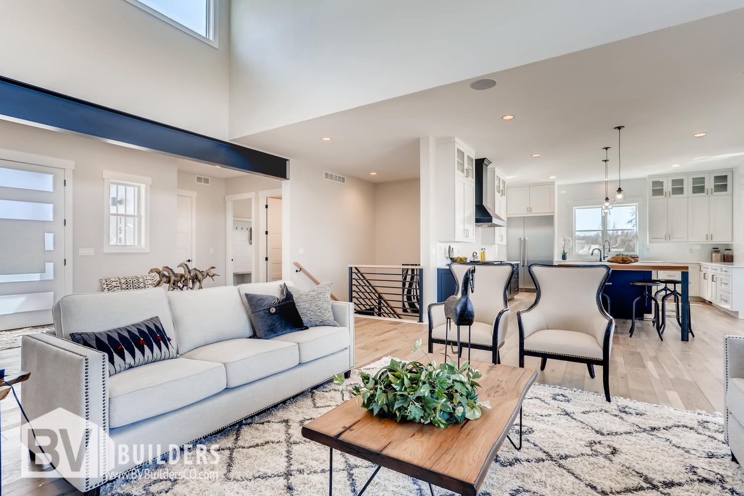 Modern farmhouse great room living room with exposed steel beam and open concept kitchen