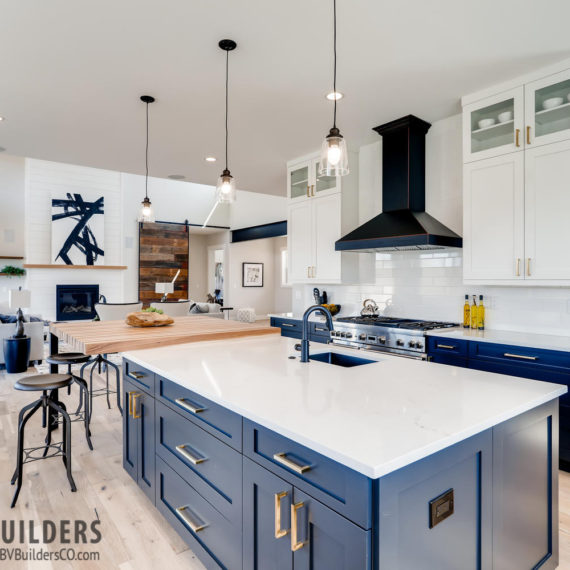 Modern farmhouse kitchen with dark blue cabinets, white subway tile backsplash, butcher block bar and Thermador range