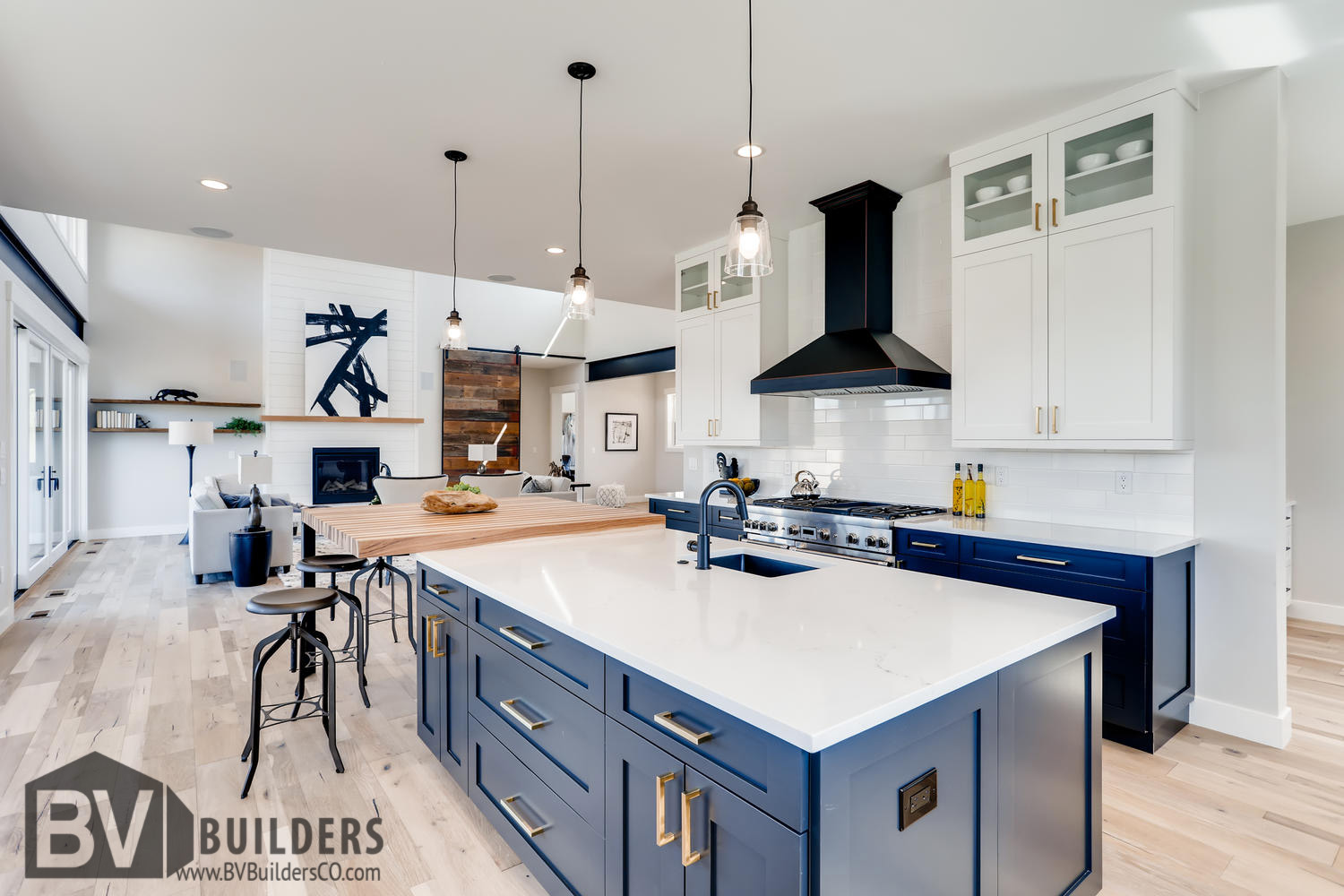 Modern farmhouse kitchen with dark blue cabinets, white subway tile backsplash, butcher block bar and Thermador range