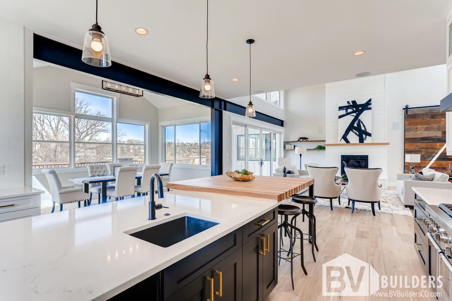 Modern farmhouse kitchen with exposed steel beams, barn door and butcher block bar