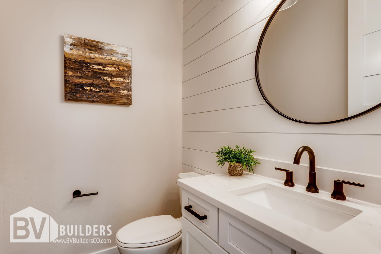 Powder room with shiplap wall and circular round mirror